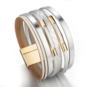 Détail du bracelet multicouche en cuir argenté avec fermoir magnétique doré et motif serpent