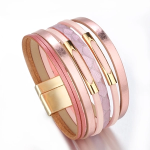 Gros plan du bracelet multicouche en cuir tressé rose avec fermoir magnétique doré poli