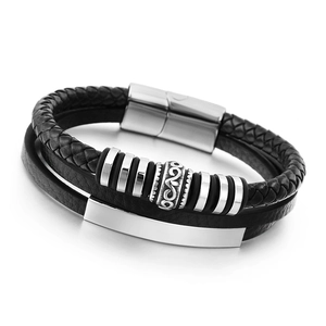 Detail of multi-layer black leather bracelet with steel scroll bead and metal plaque