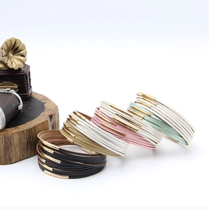 Details von mehrlagigen Lederarmbändern in fünf Farben mit goldenen Metallröhren-Anhängern