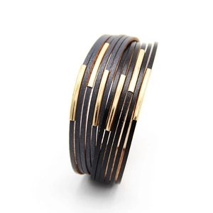 Mehrlagiges schwarzes Lederarmband mit goldfarbenen Metallröhren auf weißem Hintergrund