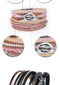 Macro detail of multilayer woven bracelet featuring rhinestone strips and a shell charm