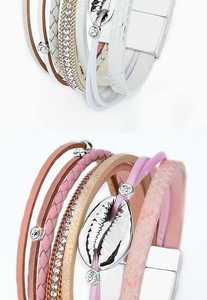 Detail of bohemian multilayer leather bracelets with cowrie shells and magnetic clasps