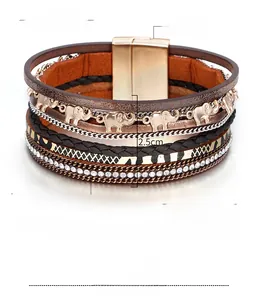 Détail montrant le pendentif éléphant, l'imprimé léopard et le cuir tressé du bracelet