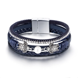 Detail of bohemian multilayer leather bracelet with silver sea turtles and pearl