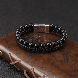 Herenarmband met dubbele laag zwarte tijgeroogkralen en leer op een vintage notitieboekje