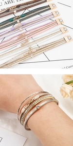 Detail von mehrlagigen geflochtenen Lederarmbändern mit Unendlichkeitssymbol und Magnetverschluss