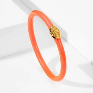 Pulsera de silicona coral vibrante con adorno de metal dorado texturizado y elegante