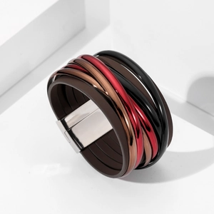 Gros plan du bracelet multicouche en cuir avec tubes métalliques et fermoir magnétique