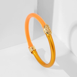 Brazalete de resina naranja traslúcida con relieve de rosa dorada sobre fondo blanco