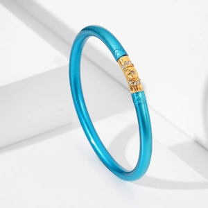 Detalle de pulsera azul de silicona con dije de estrella dorada y cristales brillantes