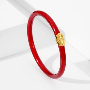 Detalle de una pulsera de silicona roja con purpurina y patrón de león dorado en blanco