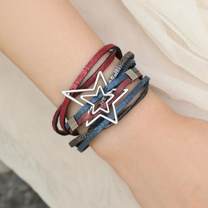 Detail eines mehrlagigen Lederarmbands mit silbernem Sternanhänger und Magnetverschluss