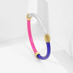 Détail d'un bracelet en silicone tricolore avec des accents métalliques dorés gaufrés