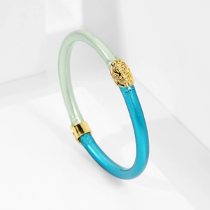 Detalle de la pulsera de resina bicolor con cierre de cabeza de león dorado y acabado perlado
