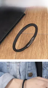 Detail of black woven wire bracelet for men with magnetic clasp and wooden background