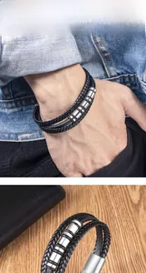 Dettaglio del bracciale multistrato in pelle intrecciata nera con ciondoli in argento uomo