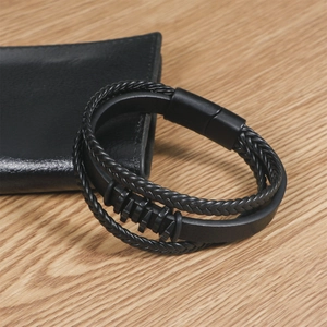 Men's multilayer black braided leather bracelet with magnetic clasp on wood background