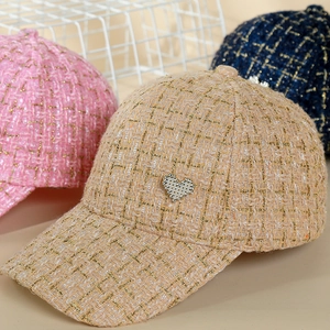 Detail of tweed baseball caps with metallic threads and rhinestone heart patches