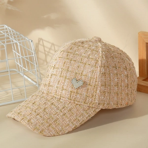 Detail shot of tweed baseball cap featuring heart-shaped pearl and rhinestone decoration