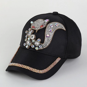 Detailed view of colorful fox rhinestones on a black cotton baseball cap surface