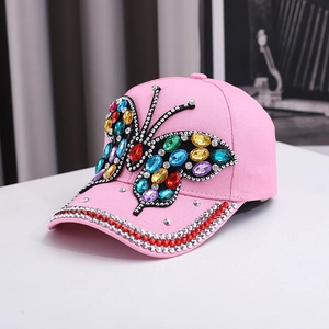 Pink baseball cap featuring a large colorful rhinestone butterfly and crystal brim accents