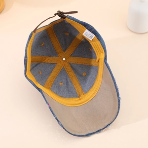 Detail view of denim baseball cap interior showing 100% cotton label and yellow lining