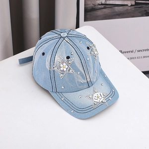 Detailed view of light blue denim baseball cap featuring rhinestone stars and white flowers