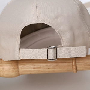 Detail view of cotton baseball cap back with adjustable silver metal buckle and stitch