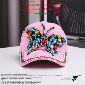 Detailed close-up of pink denim baseball cap with colorful rhinestone butterfly design