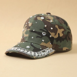 Detail view of camouflage baseball cap featuring sparkling rhinestones on brim and crown