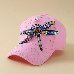 Détail d'une casquette rose avec libellule en strass multicolores et petites marguerites