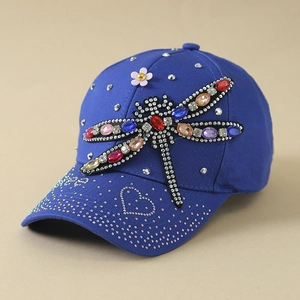 Détail de la casquette bleue avec libellule en strass colorés et motif de cœur argenté