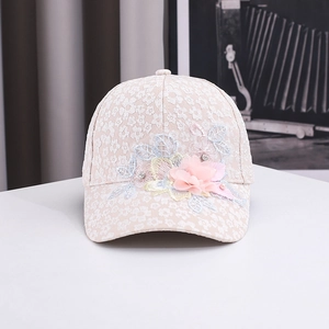 Detail of pink lace baseball cap featuring mesh flowers, pearls and rhinestones