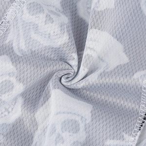 Close-up of white breathable mesh fabric with grey skull print and fine stitching