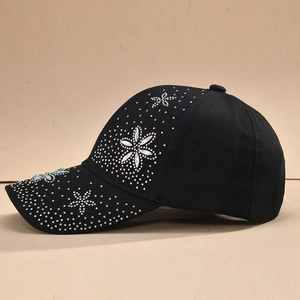 Détail de strass colorés formant des fleurs sur le bord d'une casquette noire