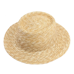 Detail of the finely woven natural wheat straw texture on a flat-top wide-brim sun hat