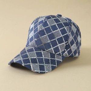 Detail of blue denim baseball cap featuring silver sequins and distressed diamond pattern