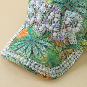 Detailed close-up of pearls and colorful rhinestones on a lace floral baseball cap