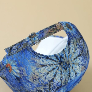 Gros plan détaillé sur le tissu en dentelle florale bleue et la boucle en métal argenté du chapeau