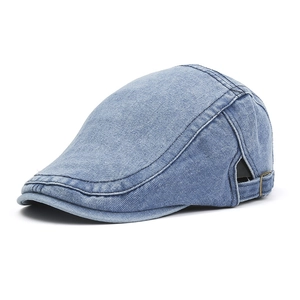 Detail of light blue denim flat cap featuring a metallic side buckle and premium stitching