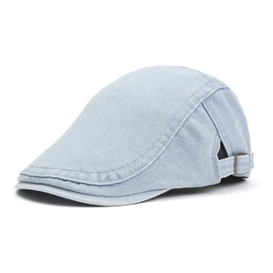 Detail of adjustable metal buckle and denim texture on light blue cotton flat cap
