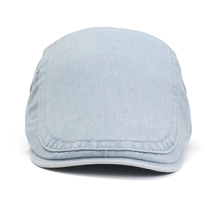 Detail view of light blue denim fabric texture on classic ivy newsboy cap crown
