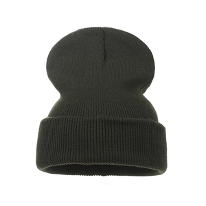Close-up of deep dark green knitted beanie showing thick ribbed texture and folded cuff
