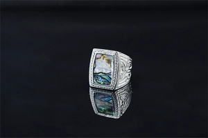 Detail of vintage silver ring with rectangular abalone shell inlay and carved relief
