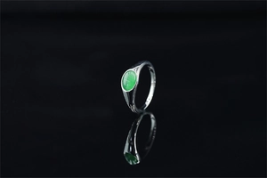 Vista macro dell'anello a sigillo con gemma occhio di gatto verde su sfondo nero lucido