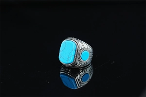 Close-up of vintage turquoise ring with intricate ethnic engravings on silver metal