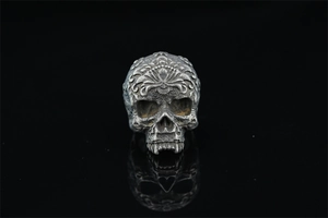 Macro shot of vintage skull ring featuring intricate baroque engravings and silver finish