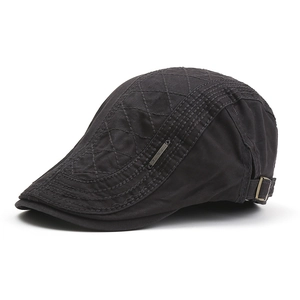 Detail of grey cotton flat cap featuring quilted diamond patterns and metal logo side plate