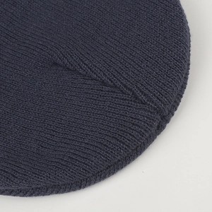 Detailed macro view of navy blue high-density knit hat with radial stitching finish